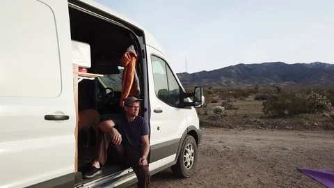 Van life off the grid, middle age man relaxing while camping in desert. Stock-Footage 87767288