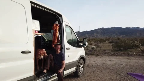 Van life off the grid, middle age man and dog relaxing while camping in desert. Stock-Footage 87767308