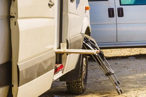 A van is parked with an open side door. A picnic fold down external table set Stock Photos