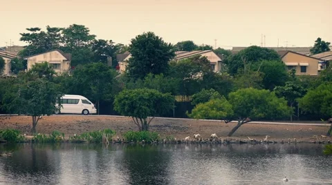 Van Passes Houses By River In Developing Country Stock Footage 57297659