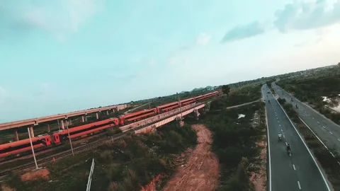Vande Bharat Express train passing over railway bridge beside highway in India Stock Footage 342190350