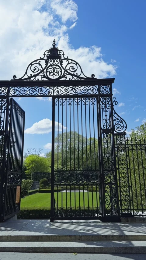 Vanderbilt Gate in Central Park Beneath Bright Sky and Spring Greenery Pan Left Stock Footage 336038485