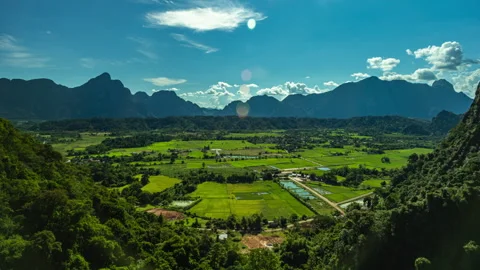 Vang Vieng Laos panoramic landscape featuring verdant rice paddies, rural Stock Footage 318283149