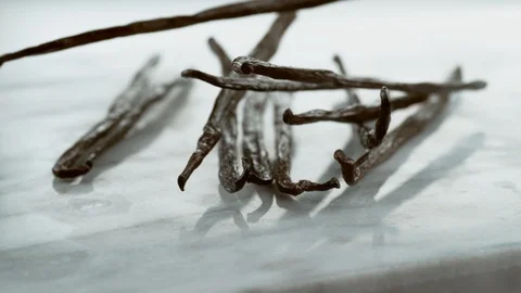 Vanilla beans falling onto marble surface in slow motion.  Shot on Phantom Flex Stock Footage 130359556