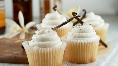 Vanilla beans falling onto vanilla bean cupcakes in slow motion.  Shot on Vidéo 130359366
