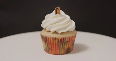 Vanilla chai cupcake spinning on turntable on black background Stock Footage 249373757