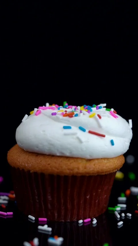 Vanilla Cupcake with Rainbow Sprinkles Rotating on Dark Background Stock Footage 330516814
