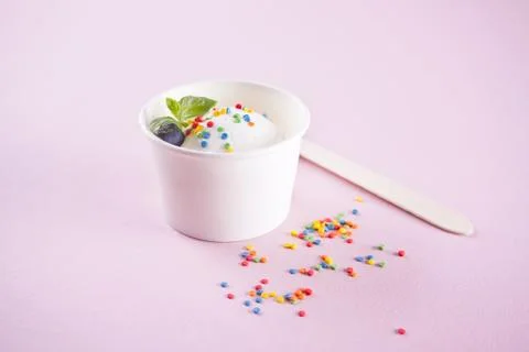 Vanilla ice cream with mint leaf and colorful candy on the pink background Stock Photos