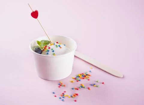 Vanilla ice cream with mint leaf, strawberries and blueberries on the pink ba Photos