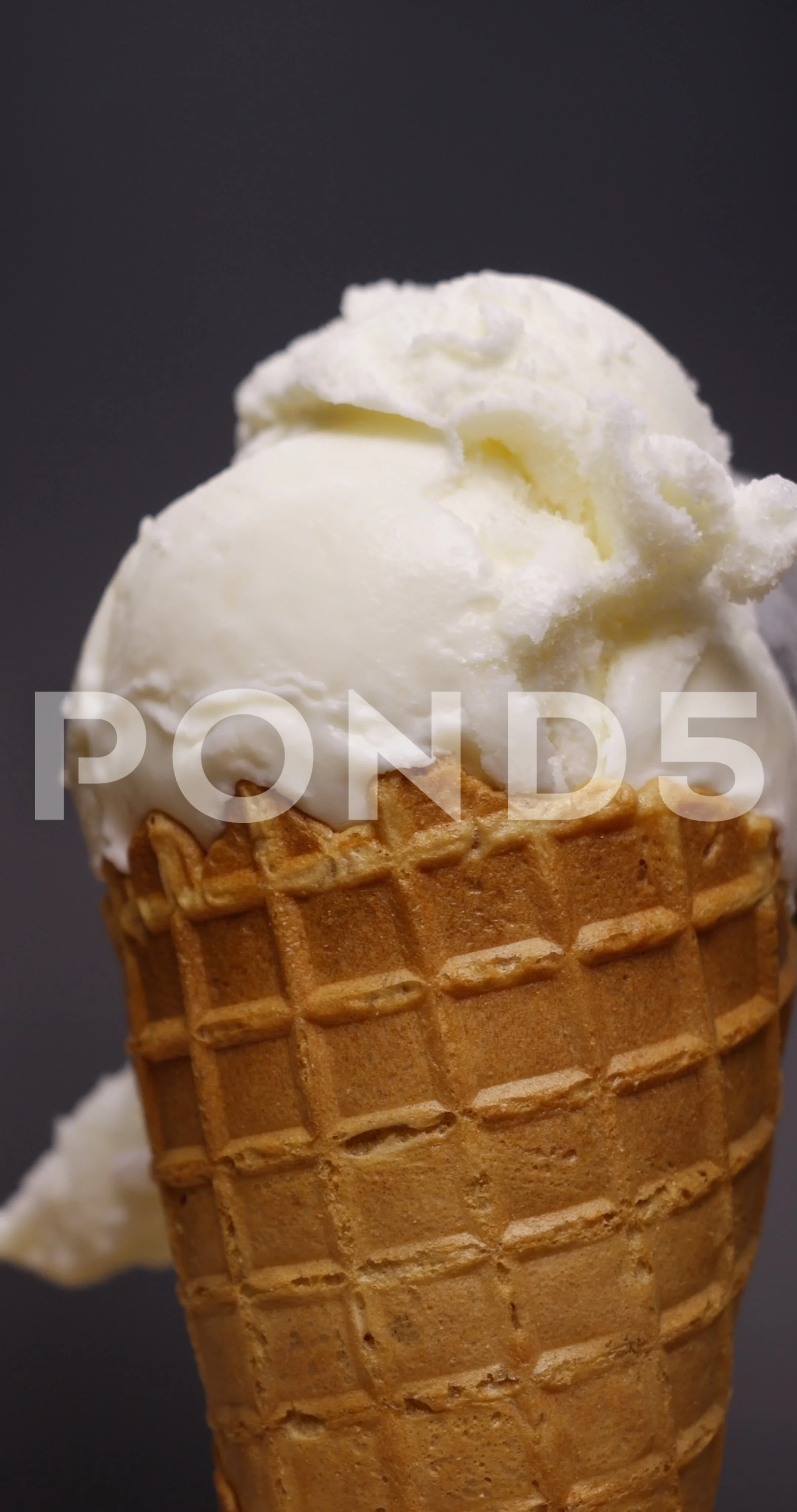 A Double Scoop Vanilla Ice Cream Cone on a Blue Background Stock Photo