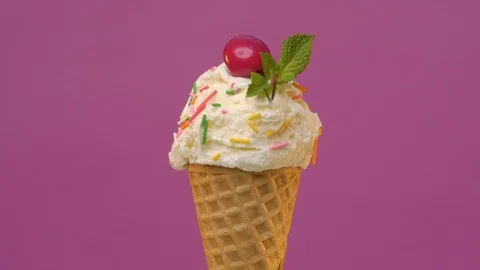 Vanilla ice cream scoop in waffle cone with green mint leaf and fresh cherry Stock Footage 108730171