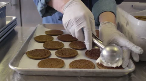 Vanilla ice cream scoops being placed on cookies to make ice cream sandwiches 스톡 동영상 60157096