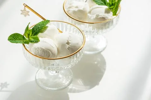 Vanilla ice cream scoops with mint in elegant bowls Stock Photos