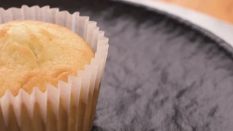 Vanilla Muffin Cupcake Rotating On Black Plate Close Up Video stock 126164194