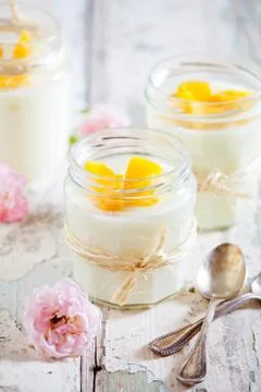Vanilla Pudding With Mango In Small Jars Stock Photos
