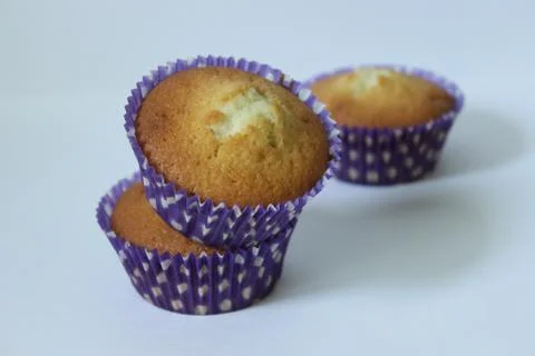 Vanilla three cupcakes in a blue wrapper .Texture or background Stock Photos