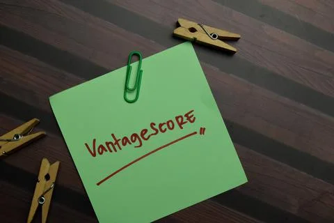 Vantagescore write on sticky notes isolated on Wooden Table. Stock Photos