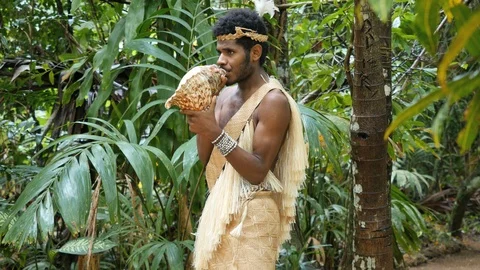 Vanuatu man blowing a conch shell horn Stock Footage 123138068