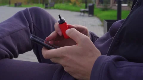 Vape and Phone in Hand. Electronic cigarette and mobile telephone in the hands Stock Footage 252244643