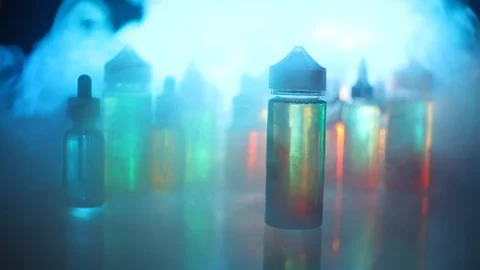 Vape concept. Smoke clouds and vape liquid bottles on dark background