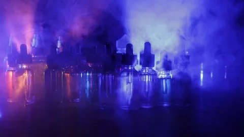 Vape concept. Smoke clouds and vape liquid bottles on dark background