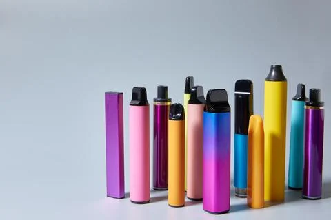 Vape e-cigarettes on a gray background with a place for text or product adv.. Stock Photos