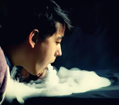 Vape trick waterfall in performance of vaper on dark background Stock Photos