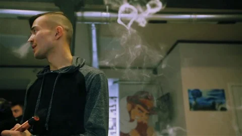 Vape. White guy lets rings out of steam with electronic cigarette. Stock Footage 73178741