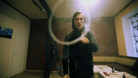 Vape. White guy lets rings out of steam with electronic cigarette. Stock Footage 73178836