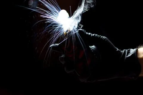 Vaper steam explosion on a black background with protective gloves. Stock Photos
