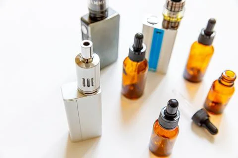 Vaping device e-cigarette electronic cigarette and liquid bottles isolated .. Stock Photos