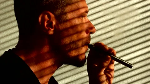 Vaping e cigarette in the window blinds shadow Stock Footage 58190670