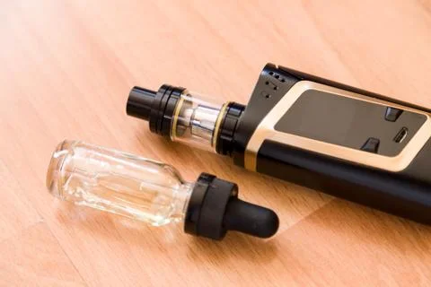 Vaping electronic mod and vape liquid Stock Photos
