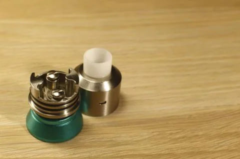 Vaping rebuildable dripping atomizer (RDA) on wooden surface with copy spac.. Stock Photos