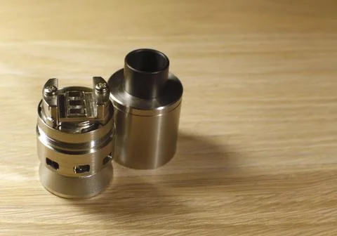 Vaping rebuildable dripping atomizer (RDA) on wooden surface with copy spac.. Stock Photos