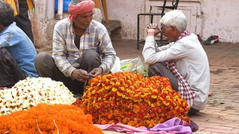 VARANASI, INDIA - MAR 10, 2019: Unidentified people sell flowers for the Stock Footage 105688745