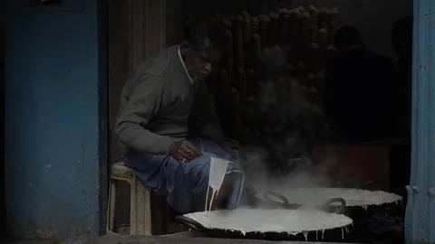 VARANASI, India - sequence of Indian man pasteurizing milk in two large pans Stock-Footage 85421637