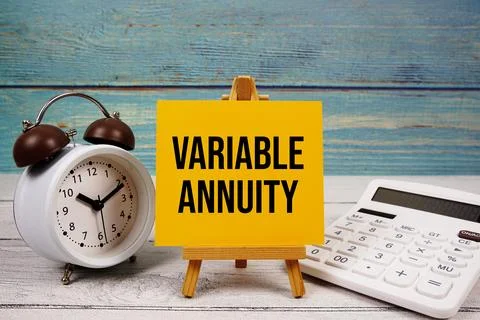 Variable Annuity text written on paper card with calculator and alarm clock.. 스톡 사진