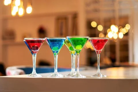 Variation alcoholic drinks served on bar counter. Colored drinks in glasses. Фото