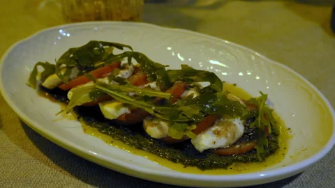 Variation of Caprese salad close-up on an oval white plate Stock Footage 303472309