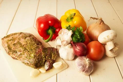 Variation of fresh and tasty vegetables and a lamb culotte on wooden table Stock Photos