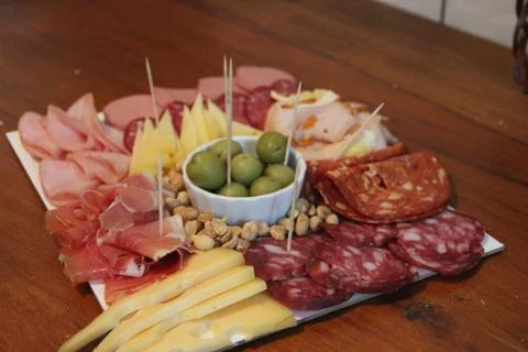 Variations of cheese and salami on table Stock Photos
