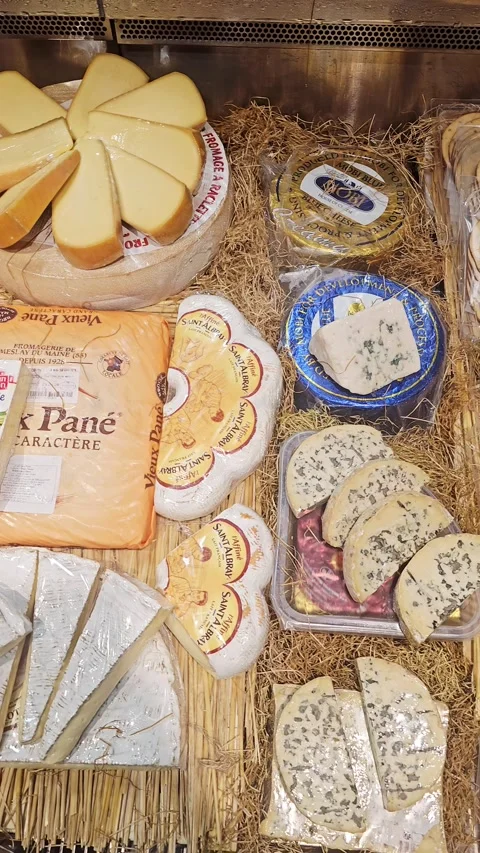 A varied selection of artisan cheeses, packaged snacks, and sliced dairy Video stock 344771579