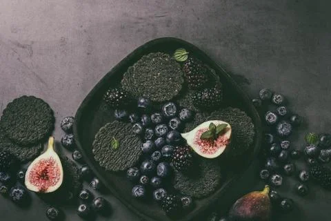 Variety of berries and figs with black crackers Stock Photos