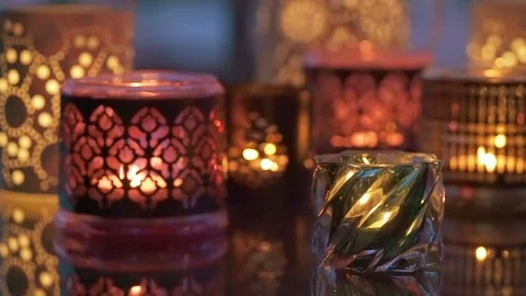 Variety of candles lights with reflection on a glass table in evening Stock Footage 76717096