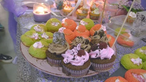 A variety of capkakes on the decorated table Stock Footage 77106629