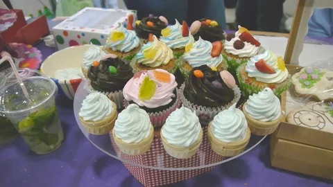 A variety of capkakes on the decorated table, top view Video stock 77106601