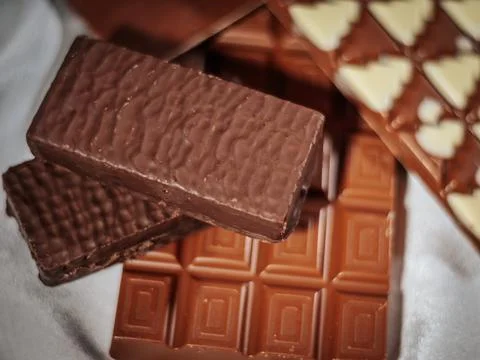 A variety of chocolate bars, including milk chocolate with geometric patterns. Stock Photos