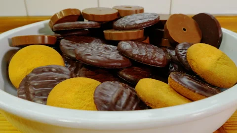 Variety of chocolate coated circular biscuits in a bowl. Video stock 239059379
