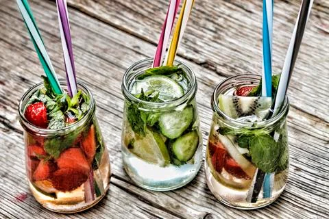 A variety of cold drinks in small bottles with pieces of fruit wooden backgro Fotos de archivo